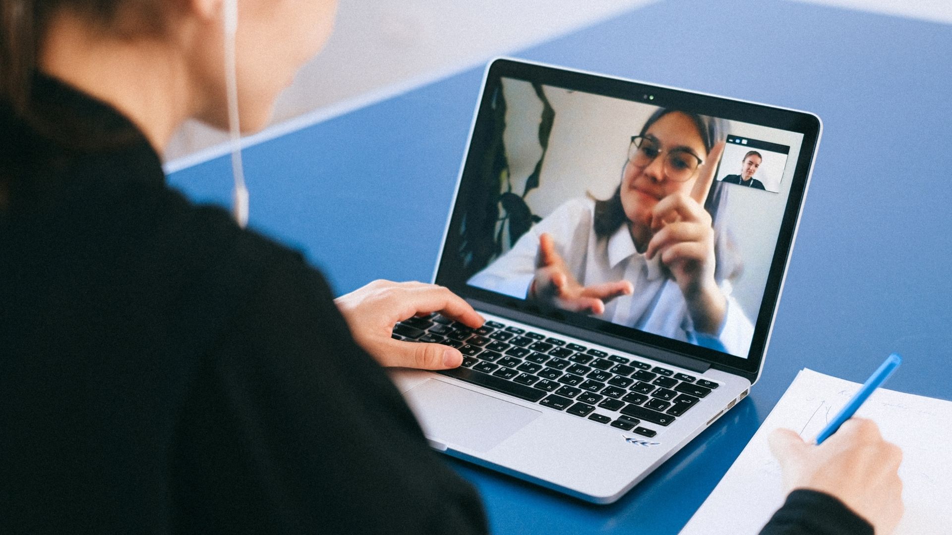A recruiter using a laptop to review a candidate's pre-recorded video interview on the Evalufy platform.